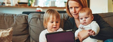 woman with 2 children looking at ipad together