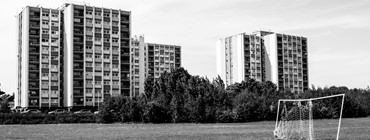 black and white photo of block of flats overlooking park 